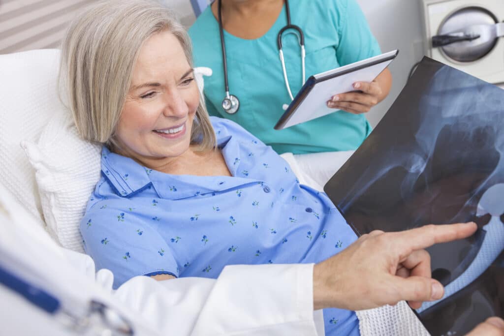 A doctor showing a woman an x-ray of her hip after a hip replacement