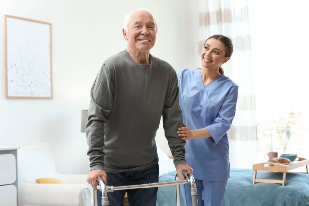 Man happily using a walker to walk after receiving a hip replacement